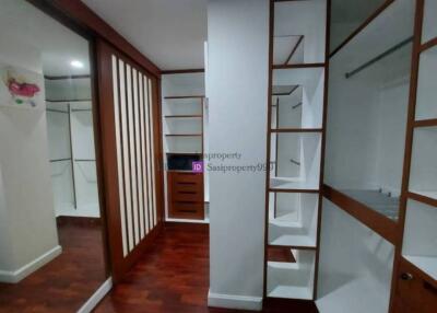Spacious walk-in closet with wooden flooring