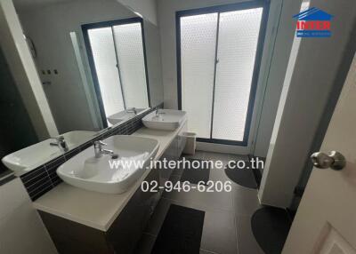 Modern bathroom with double sinks and frosted glass doors