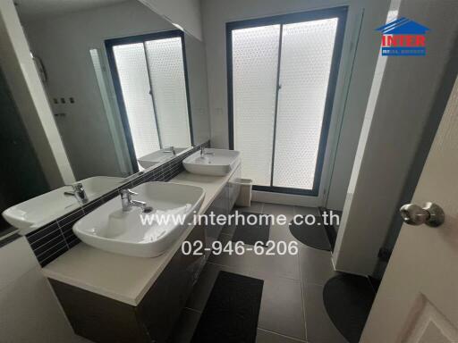 Modern bathroom with double sinks and frosted glass doors