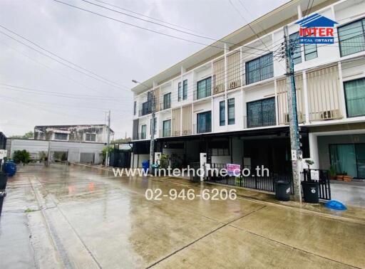 Three-story residential building on a rainy day