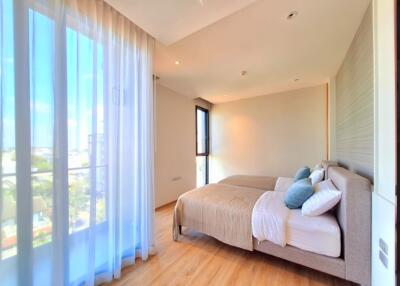 Bright and spacious bedroom with two beds and large windows