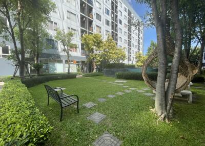 Garden area with benches and pathway near a residential building