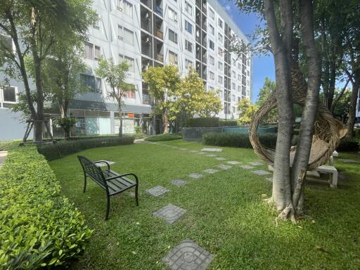 Garden area with benches and pathway near a residential building