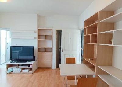 Living room with wooden shelves and TV