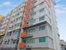 Multi-story apartment building with 'For Sale' sign