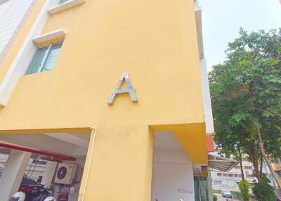Front view of building with yellow exterior and letter A