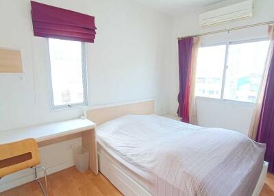 Bright bedroom with desk and large windows