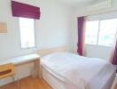 Bright bedroom with desk and large windows