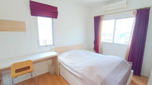 Bright bedroom with desk and large windows