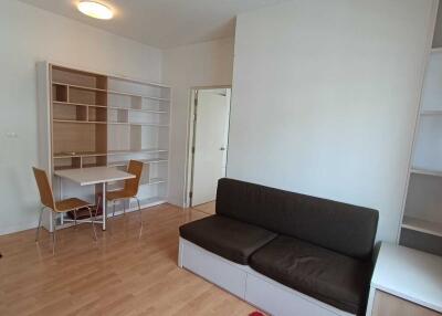 Living area with sofa, table, chairs, and shelves