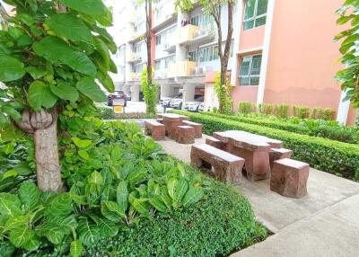 Outdoor communal seating area surrounded by greenery