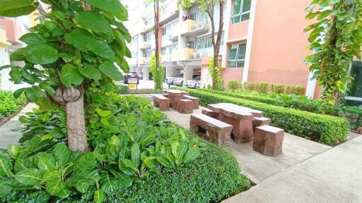 Outdoor communal seating area surrounded by greenery