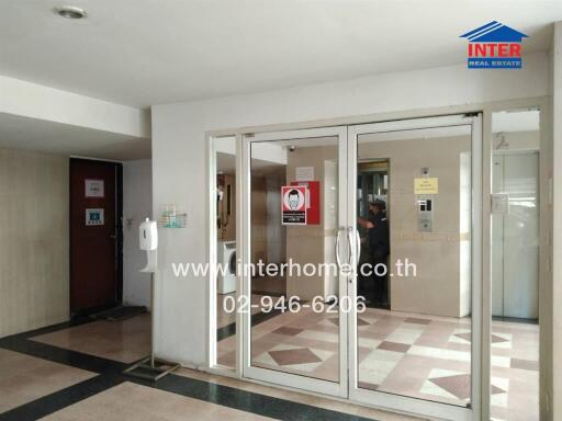 Main entrance lobby of a building with glass doors and intercom system