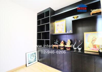 Room with dark brown built-in shelves containing various decorative items and artwork