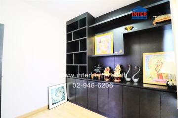 Room with dark brown built-in shelves containing various decorative items and artwork