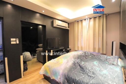 Bedroom with modern furnishings, air conditioning, and a wall-mounted TV