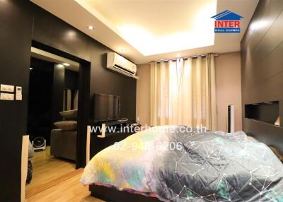 Modern bedroom with bed, TV, air conditioning, and wardrobe
