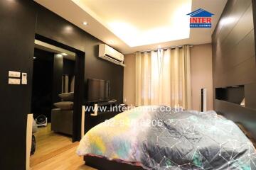 Modern bedroom with bed, TV, air conditioning, and wardrobe