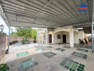 Spacious covered outdoor area with partially tiled floor