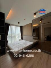 A furnished bedroom with a large window and mirrored wardrobes