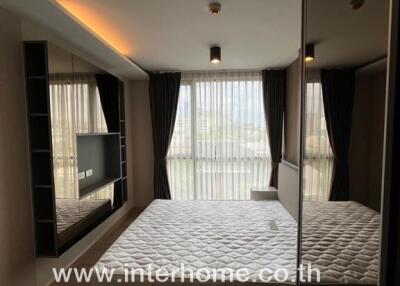 Bedroom with large window and mirrored wardrobe