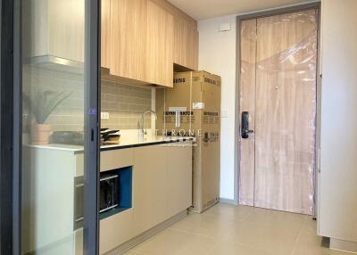 Modern kitchen with cardboard boxes and plastic-wrapped door
