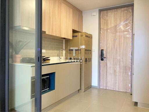 Modern kitchen with cardboard boxes and plastic-wrapped door