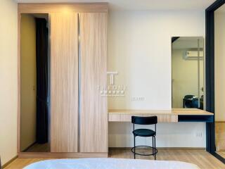 Modern bedroom with a wooden wardrobe, a work desk, and a chair