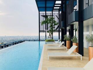 Rooftop pool area with lounge chairs and city view