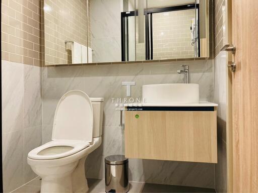 Modern bathroom with toilet, sink, and mirror cabinet