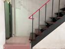 Indoor staircase with tiled floor and metal handrail