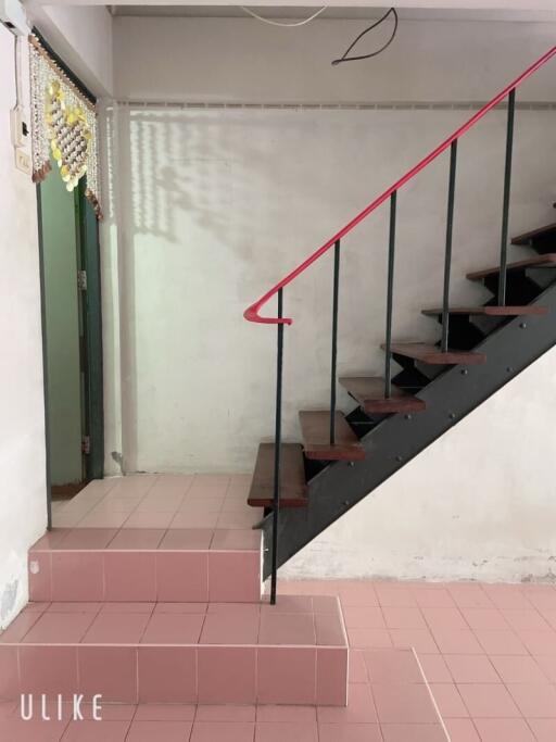 Indoor staircase with tiled floor and metal handrail