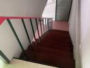 Indoor staircase with wooden steps and a door at the bottom