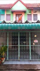 Front view of a colorful townhouse with gated porch