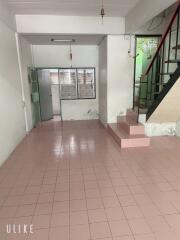 Living area with tiled floors, and staircase leading to the upper floor.