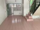 Living area with tiled floors, and staircase leading to the upper floor.