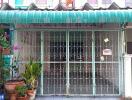 Front view of a house with a green metal gate and canopy