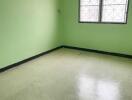 Empty bedroom with green walls and two windows