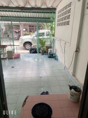 View of an open garage with tiled floor and green metal gate