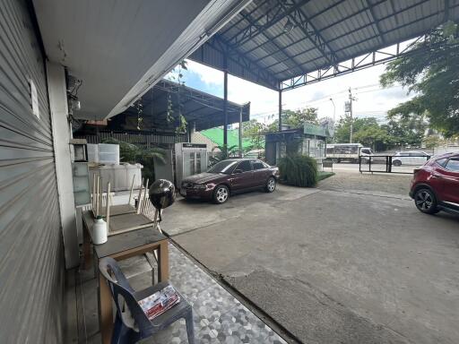 Covered parking area with cars and outdoor seating