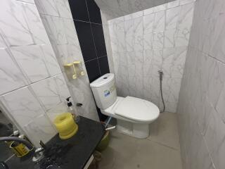 Compact bathroom with toilet and tiled walls