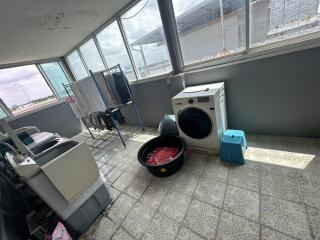 Laundry room with washing machine and clothes drying rack