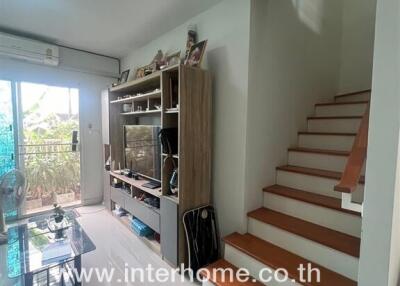 Living room with TV stand, stairway, and glass sliding door