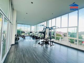 Bright and spacious gym with modern equipment and floor-to-ceiling windows