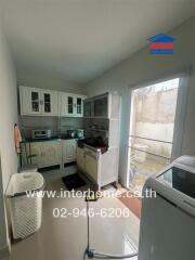 Modern kitchen with cabinets, appliances, and laundry area