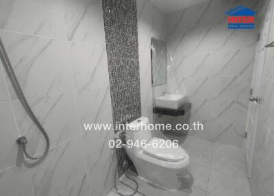 Modern bathroom with tiled walls, toilet, and sink