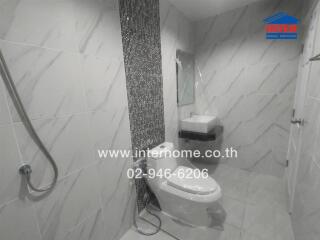 Modern bathroom with tiled walls, toilet, and sink