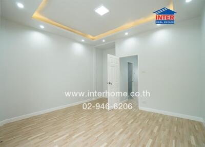 Bright empty room with wood flooring and recessed lighting