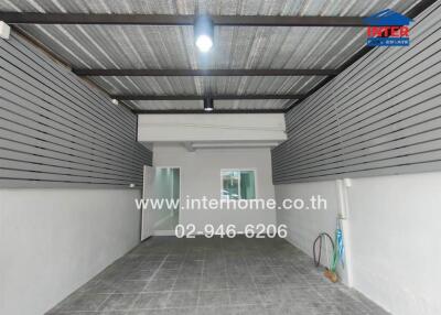 Covered parking space with sliding glass door and utility area