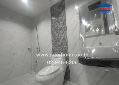 Modern bathroom with tiled walls, a shower, toilet, and sink.